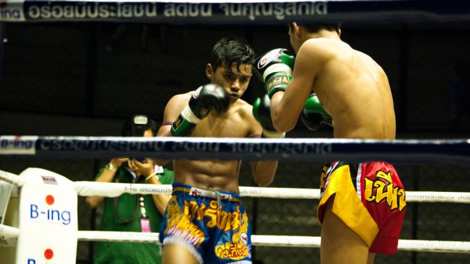 Two Muay Thai boxers fighting in Rajadamnern Stadium, Bangkok, Thailand